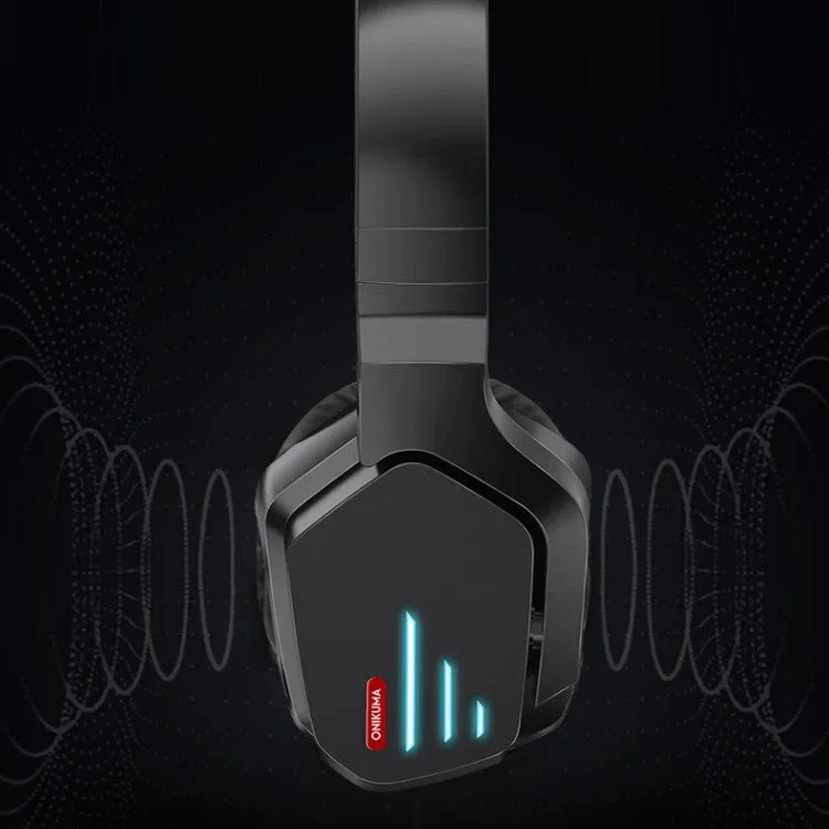 Luminous black wireless gaming headphones with head-mounted design on a desk with included 3.5mm cable and dust bag.