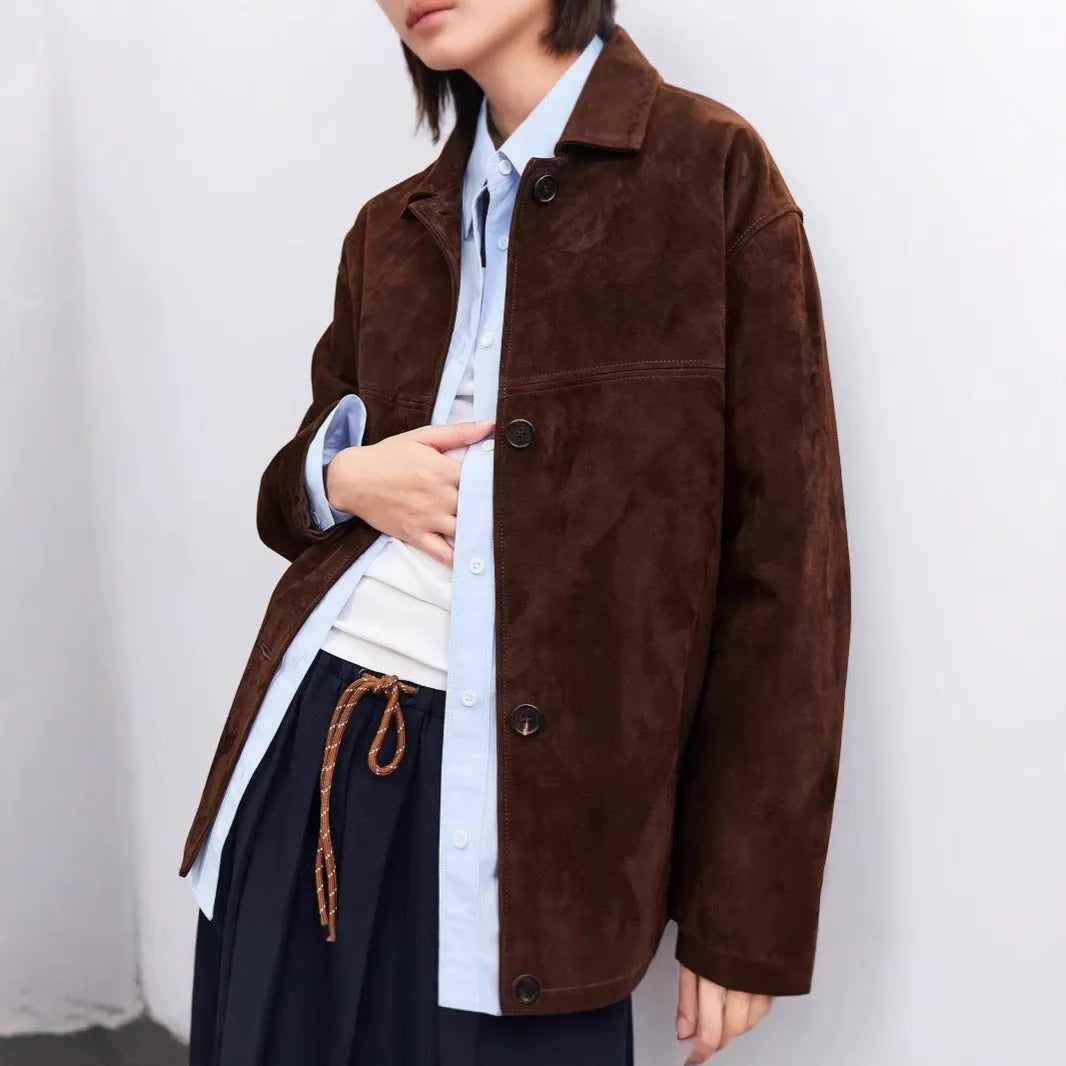 Women's belted caramel cashmere coat with leather stitching and a Peter Pan collar.