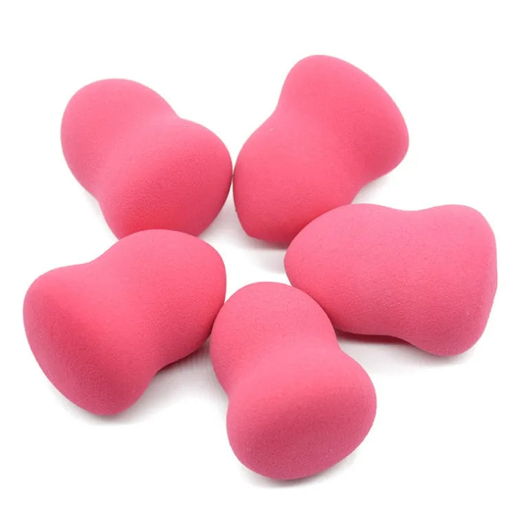 Pink makeup foundation sponge puff on a white background, showing its cubic shape and size.