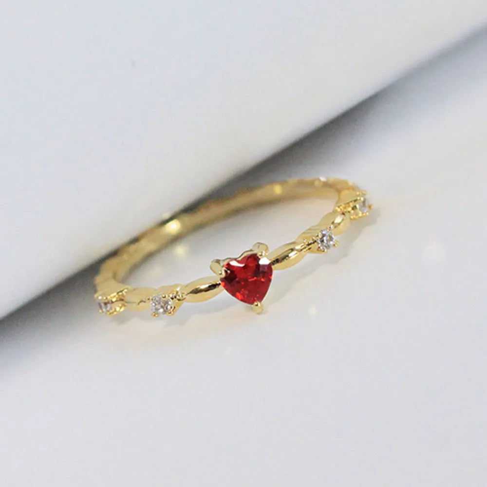 Gold or silver personalised zircon peach heart ring showing five available sizes on a ring sizer.