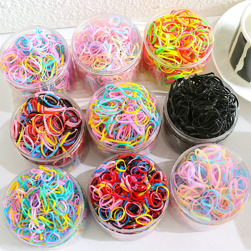 Multi-colour TPU baby hair elastic bands spilling from a reusable container.