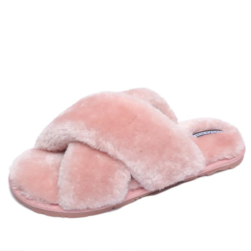 Women's black cross open-toe fur slippers with a patterned non-slip sole on a wooden floor.