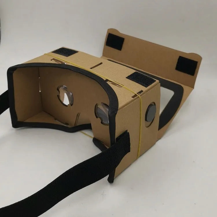 Foldable pink and white cardboard VR glasses headset with lenses and rubber head strap for smartphones.