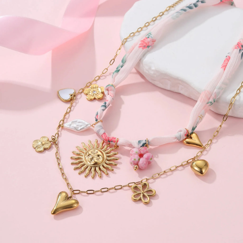 Stainless steel women's necklace with a sun pendant on a regular chain, showing heart and ribbon sun design options.