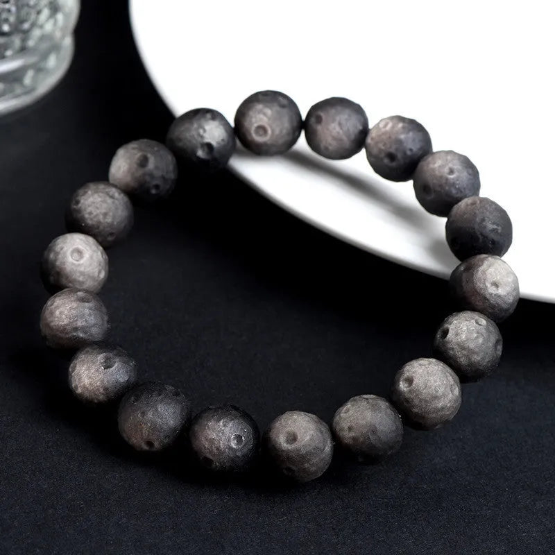 Obsidian meteorite crater ball bracelet with polished stones on adjustable string
