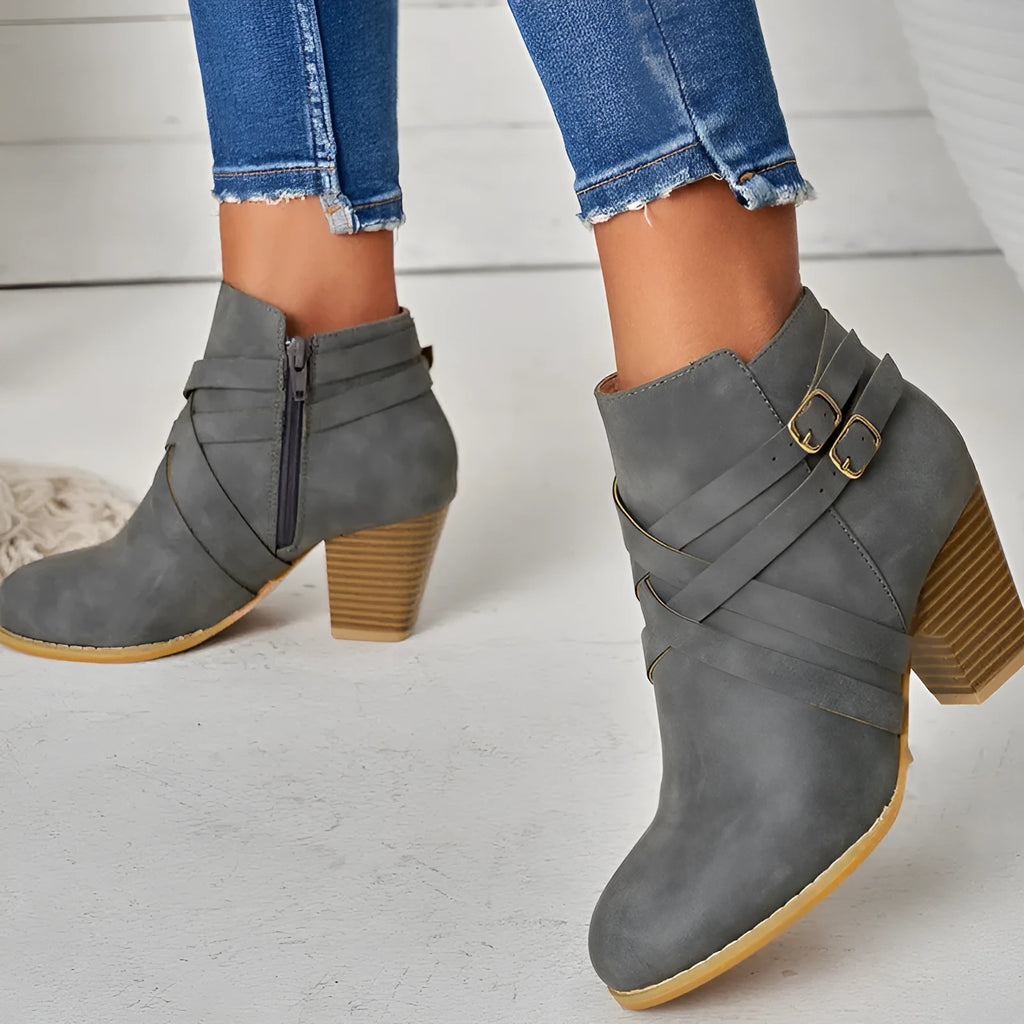 Women's grey ankle boot with a side zipper, buckle detail, and a 7cm rubber heel.
