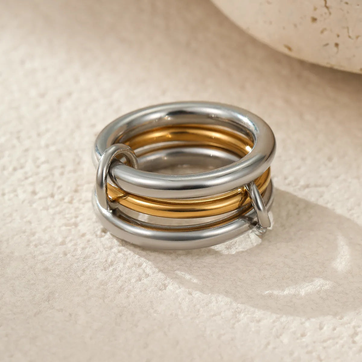Stacked stainless steel rings with gold plating in coordinated colours showing layered hand jewellery design