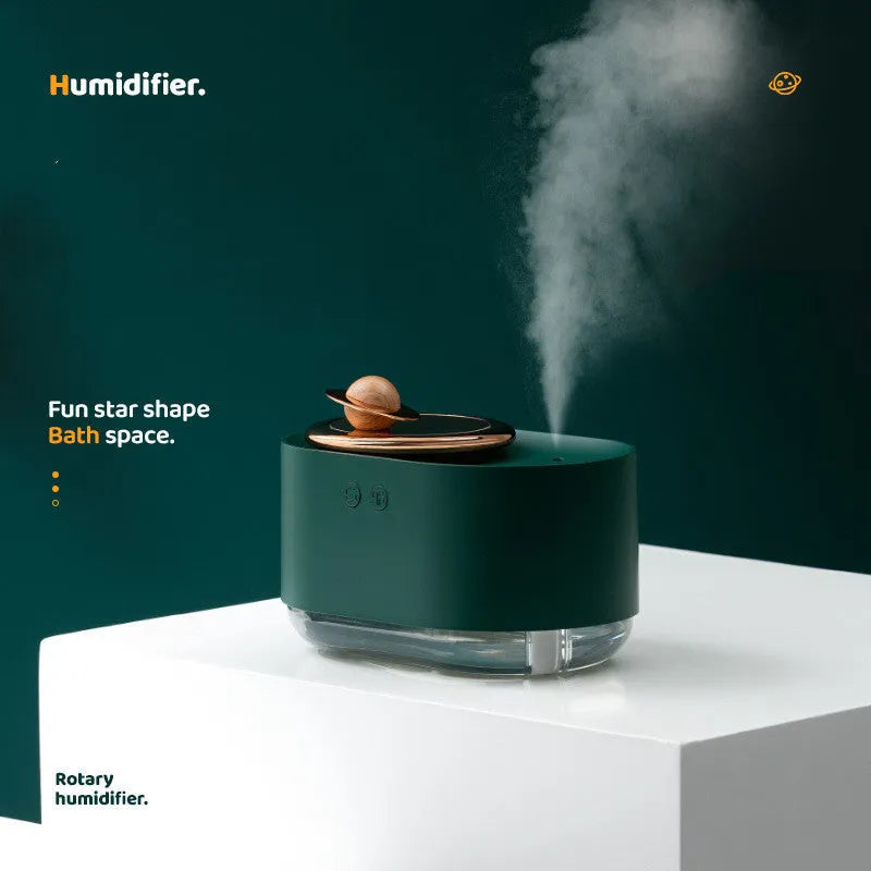 Green rotating planet-shaped desktop humidifier with night light on a wooden table.