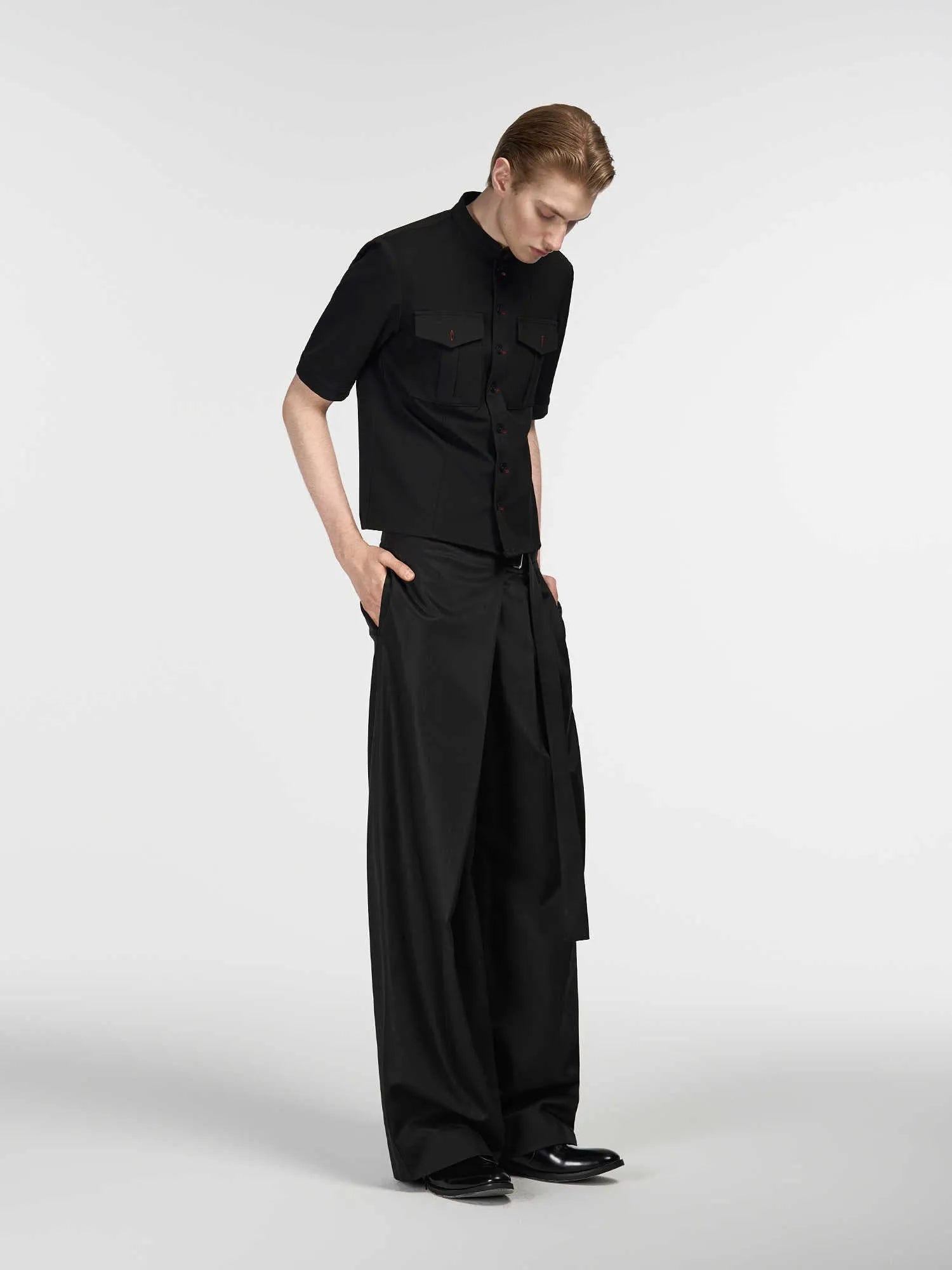 Black straight-leg women's trousers with a pleated front and adjustable waistband on a neutral background.