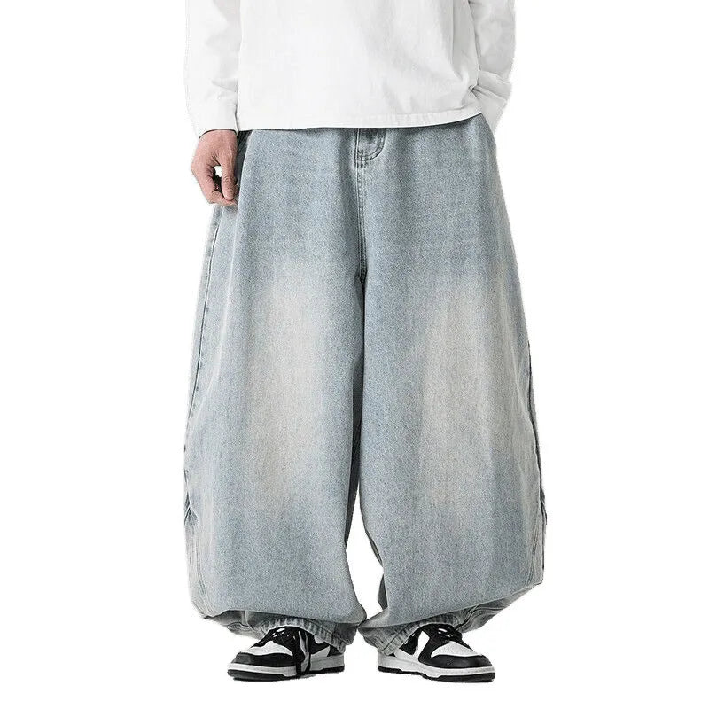 Man wearing light blue plus-size wide-leg casual denim jeans with a baggy fit and straight leg opening.