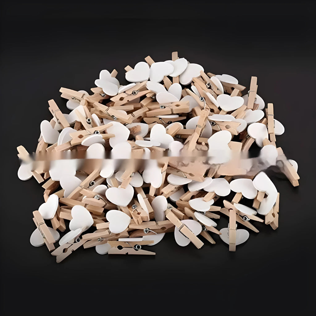 Set of five handmade solid wood heart-shaped clips in red, white, and rose red on a plain surface.