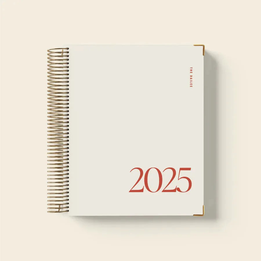 Cherry red A5 coil notebook open showing daily schedule pages and wire-o binding