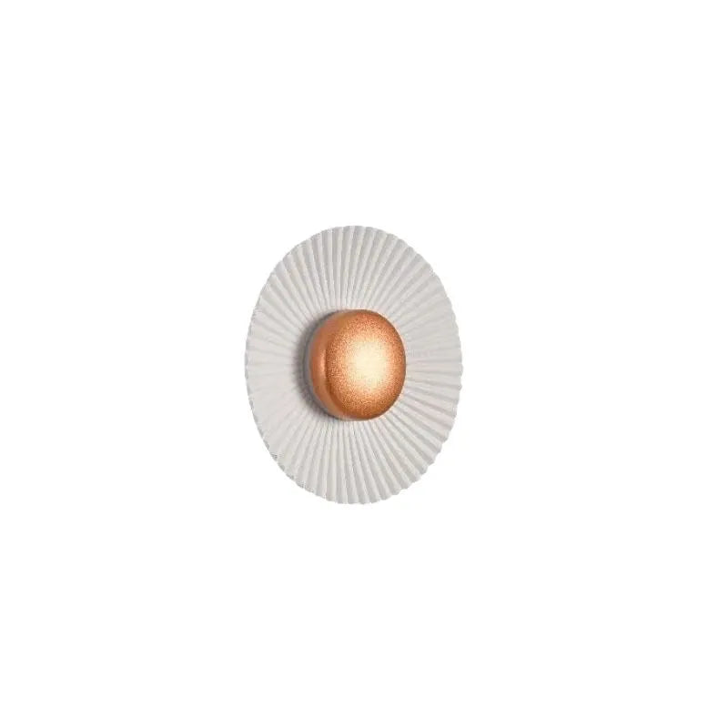 Round white and gold aluminium wall lamp mounted on a wall, LED light source visible.