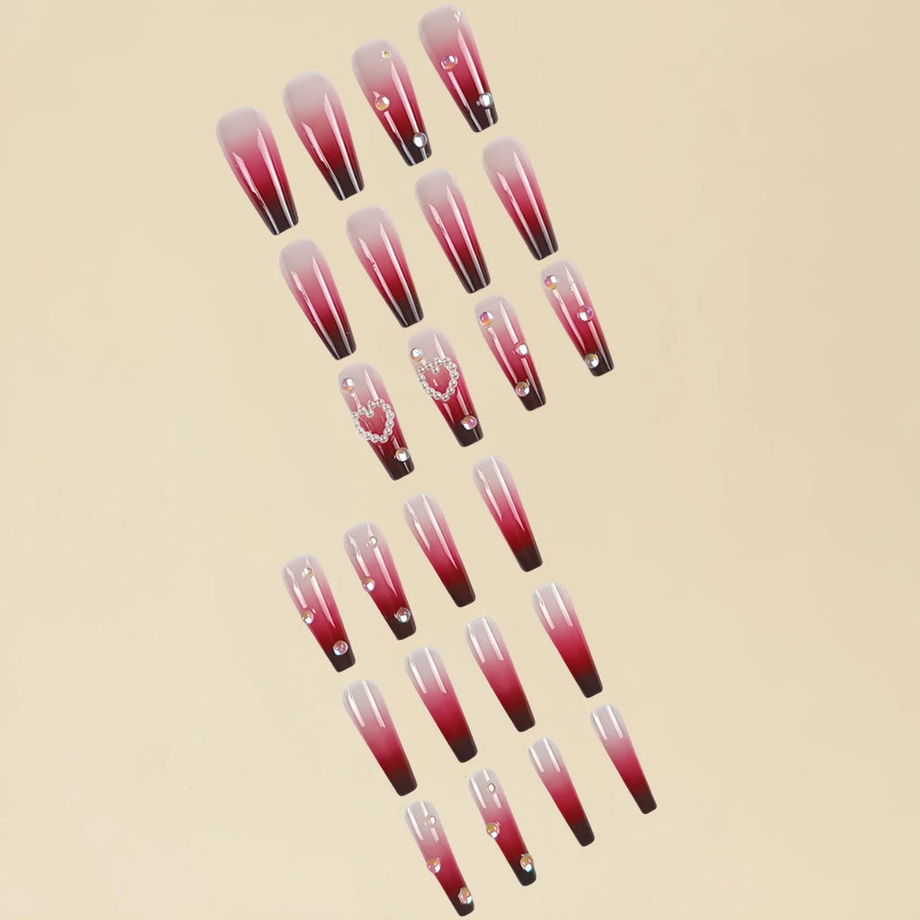 Set of long wine red gradient fake nail tips with pearl and heart design on a plaid pattern, shown with jelly glue and rubbing clause.