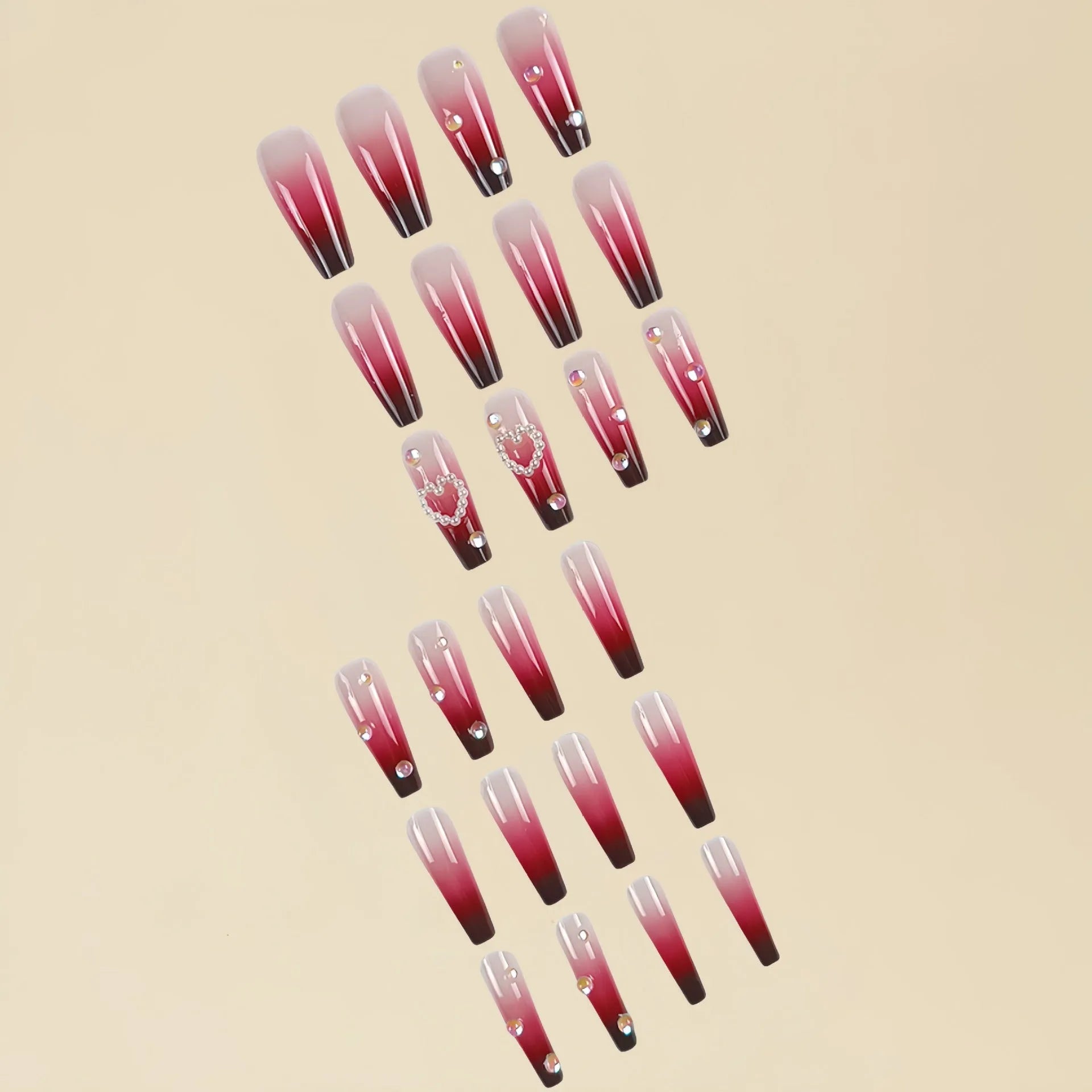 Set of long wine red gradient fake nail tips with pearl and heart design on a plaid pattern, shown with jelly glue and rubbing clause.