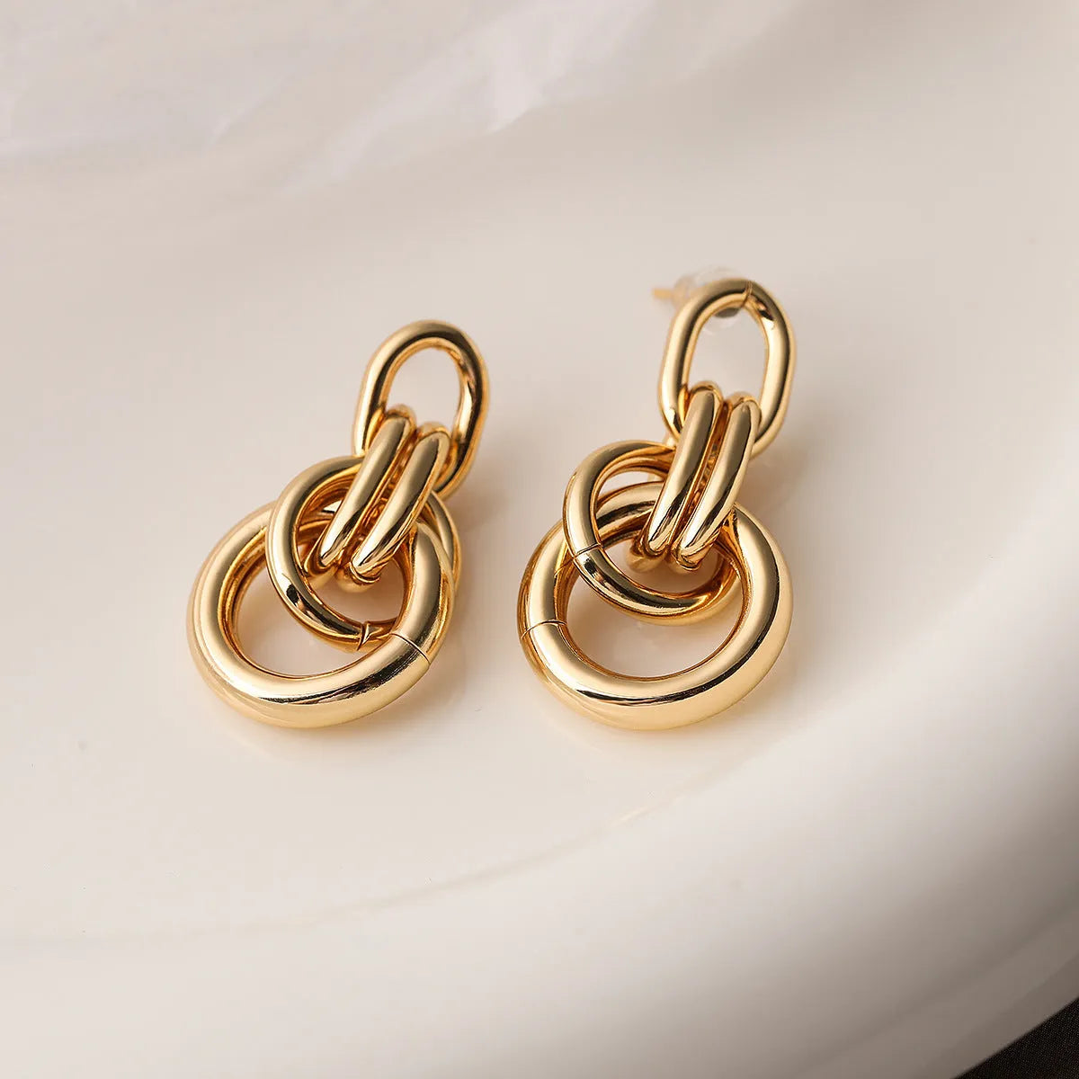 A pair of gold-coloured geometric earrings with an irregular, high-profile wild design for women.