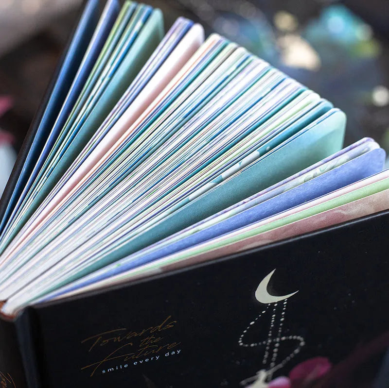 A5 notebook with luminous cover open to show internal colour illustrations, in Deep Blue, Gold, Light Blue, and Purple options