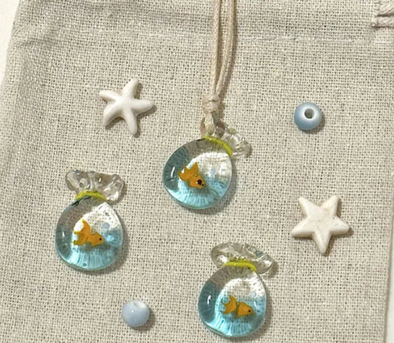 Women's coloured glaze small fish lucky bag pendant on a cotton linen clavicle chain necklace.