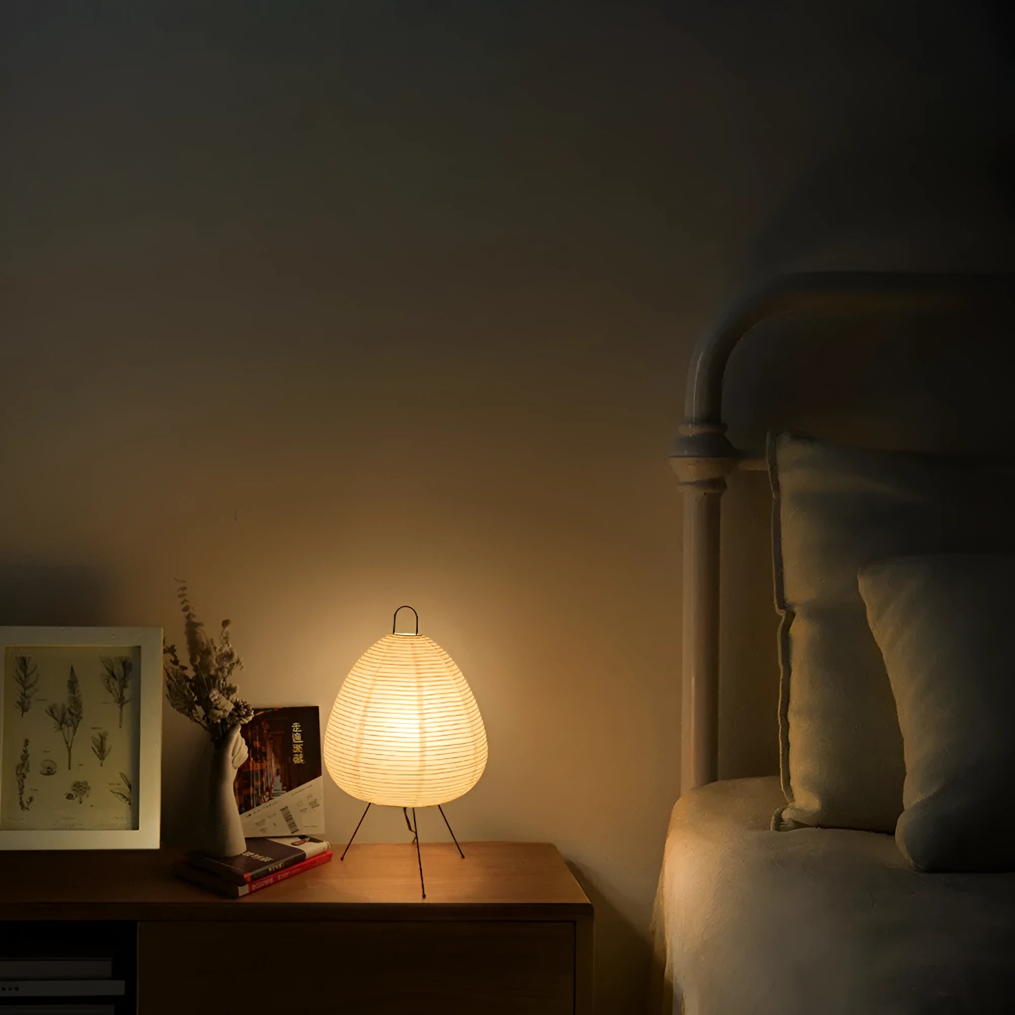 Japanese style rice paper table lamp with aluminium base on a wooden table.