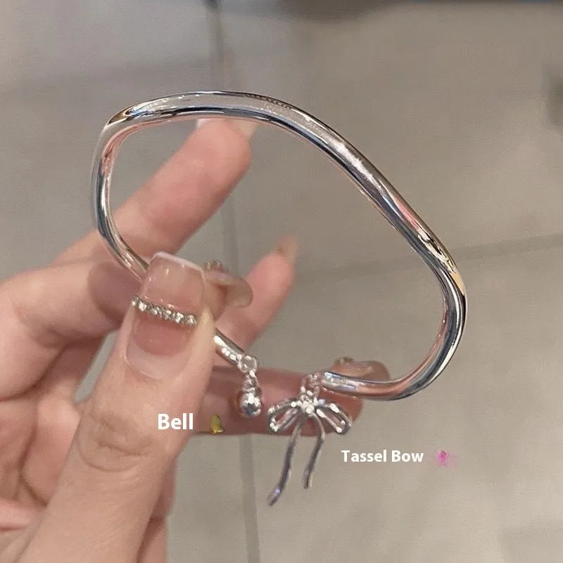 Silver bow adjustable bracelet with bell opening clasp on wrist