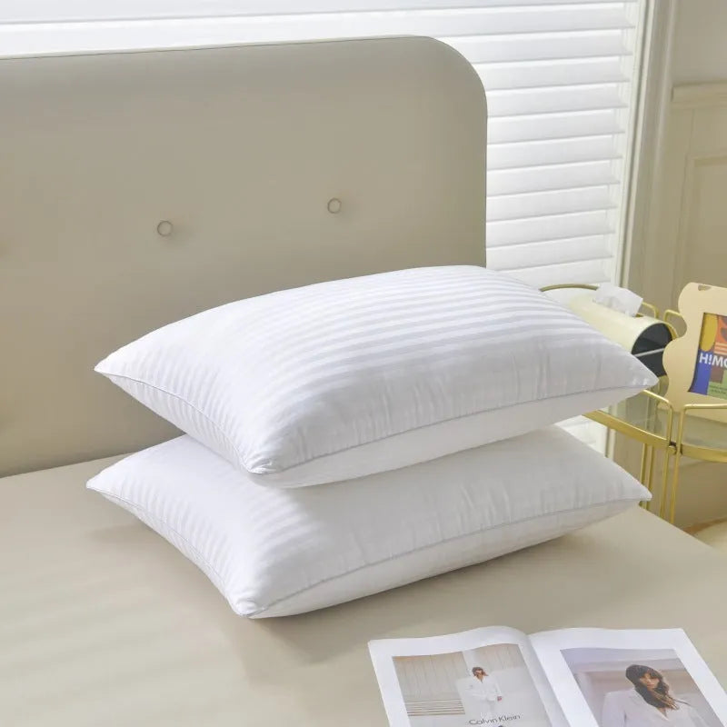White cotton satin stripe feather pillow showing simple design on a bed.