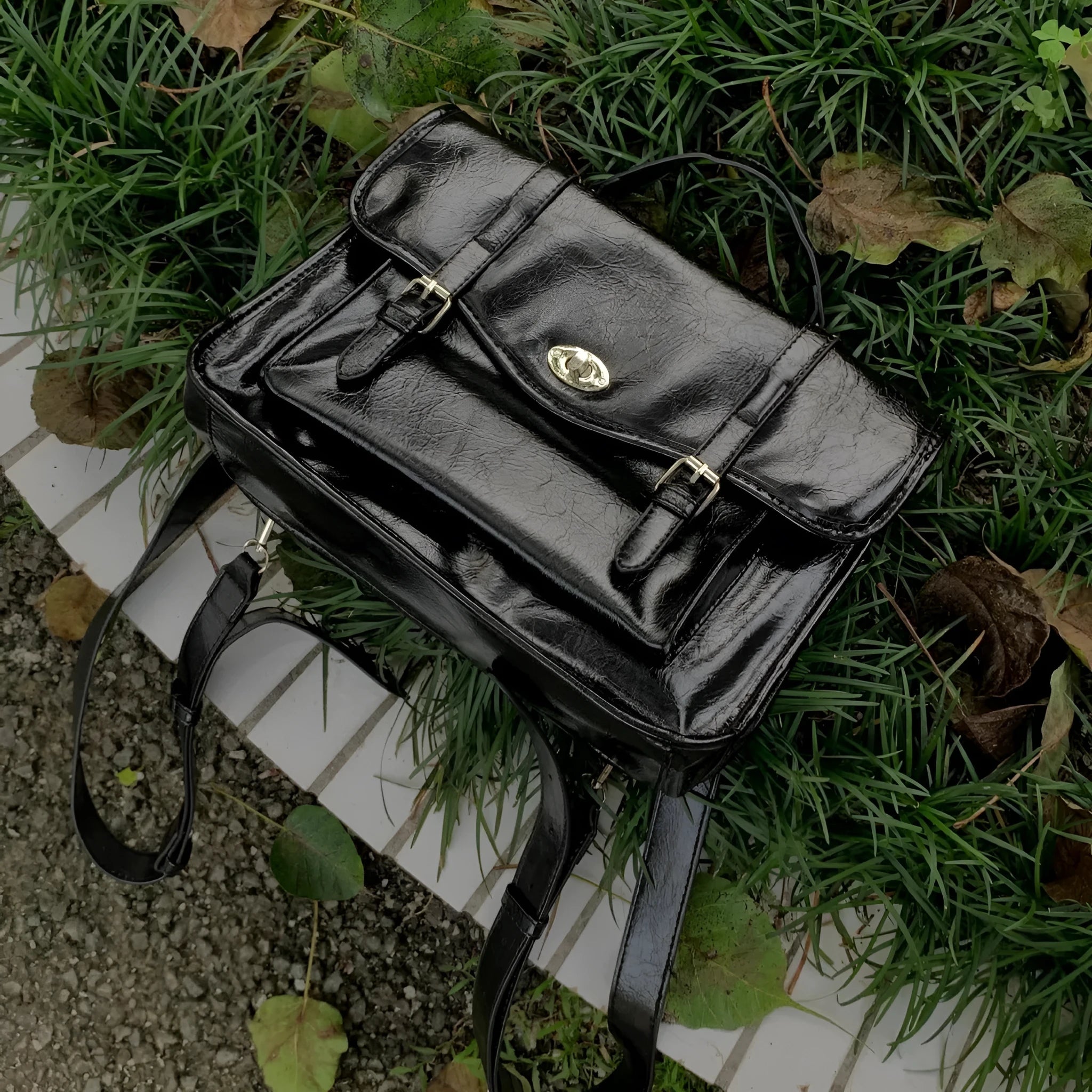 Black college style messenger bag with oil wax leather-look PU material, showing front and strap.