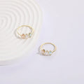 Women's gold-coloured ring with a horse eye design and three coloured zircon stones on a geometric band.