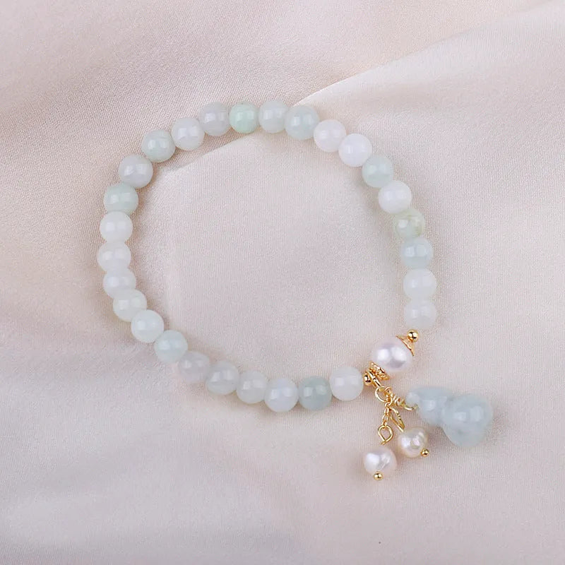 Emerald green jade bracelet with a raised gourd design in a Chinese style.