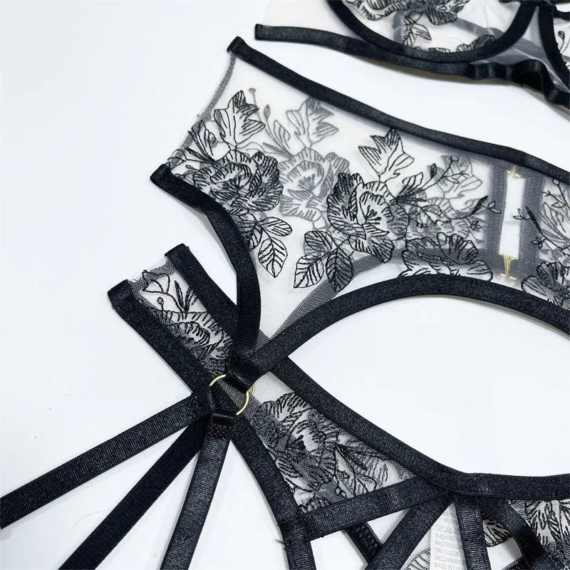 Black floral lace women's three-piece set with top, trousers, and waist cincher on a hanger.
