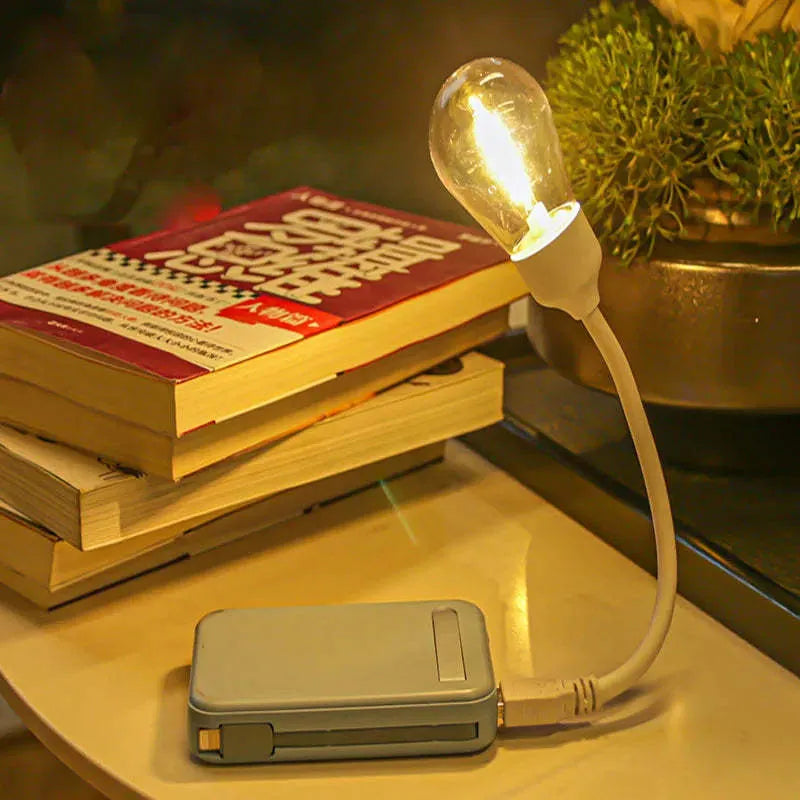 A folding USB rechargeable night light with a warm white tungsten filament S14 bulb visible.