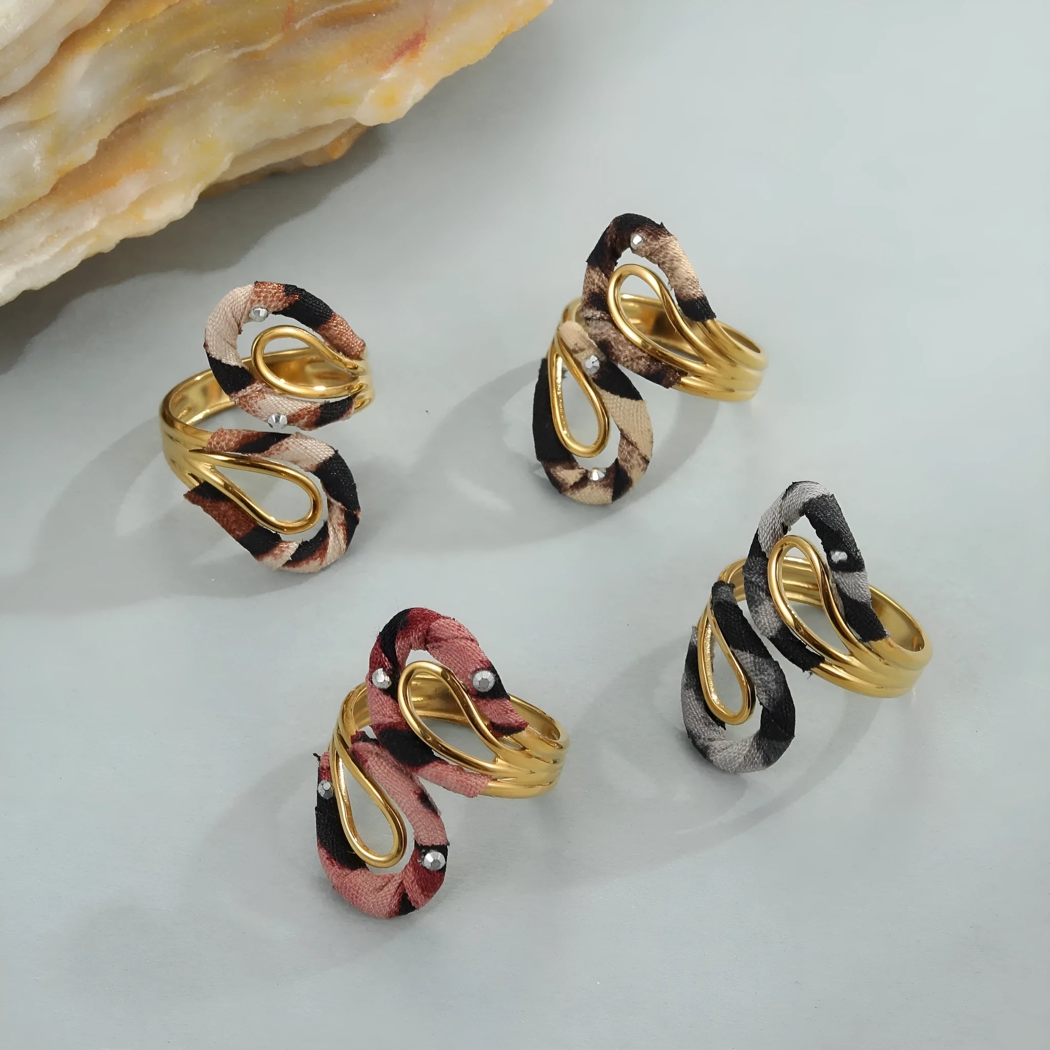 Leopard print geometric open mouth ring on a finger, showing heart shape and adjustable stainless steel band.