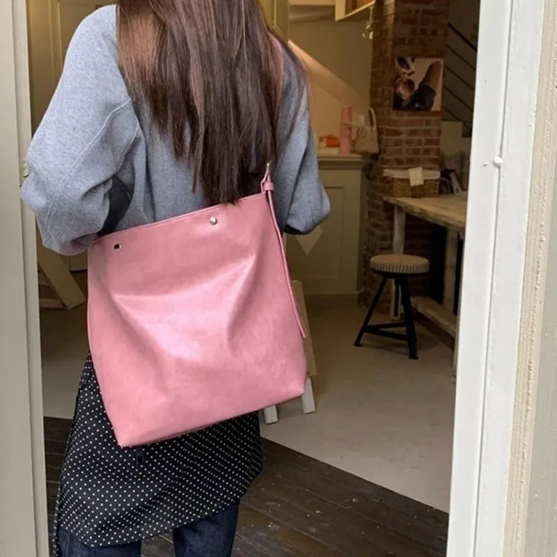 Pink corduroy one-shoulder bag with a single strap, shown next to a brown colour option.