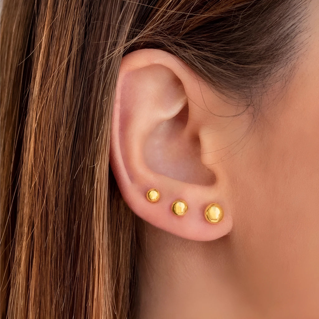 Stainless steel ball stud earrings in gold and silver, shown in 3mm, 4mm, 5mm, and 6mm sizes