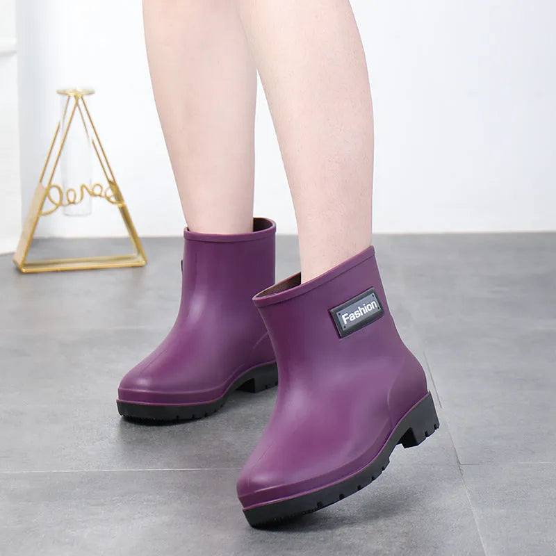 Women's mid-calf rain boots in black, PVC upper, shown with a low heel.