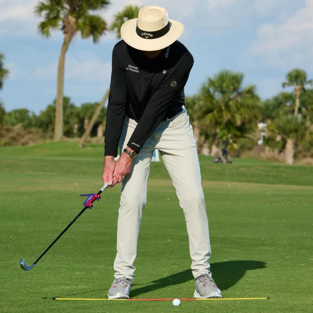 Plastic golf swing plane training simulator on practice surface