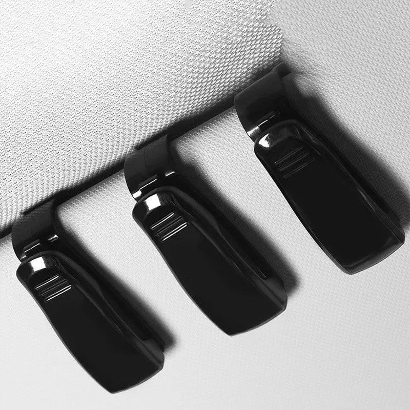 Black plastic car sun visor clip holding sunglasses and cards, measuring 6.5cm by 2.3cm