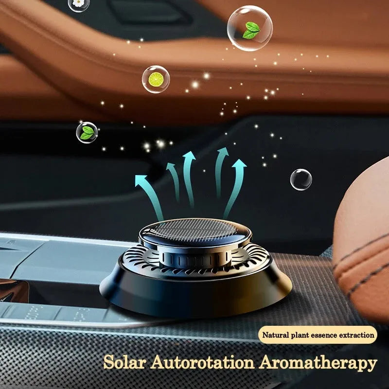 Solar-powered kinetic car air freshener with rotating double rings on a black dashboard.