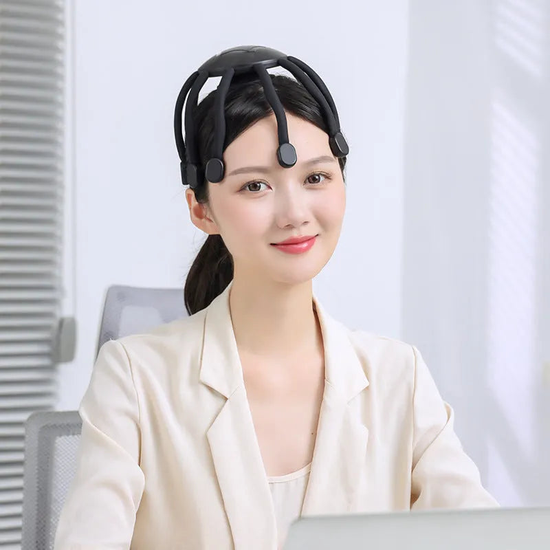 A black head massager with multiple claws, connected via a USB cable, showing its four-mode control buttons.