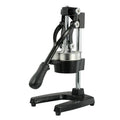 Tall black manual citrus juicer with cast iron base and stainless steel press cone on a kitchen counter
