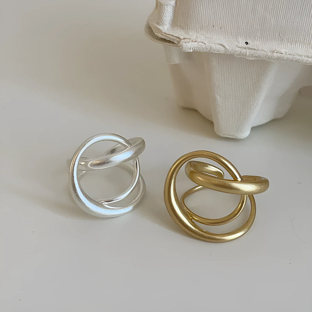 Gold and silver matte metal open rings with three-dimensional interlaced geometric design