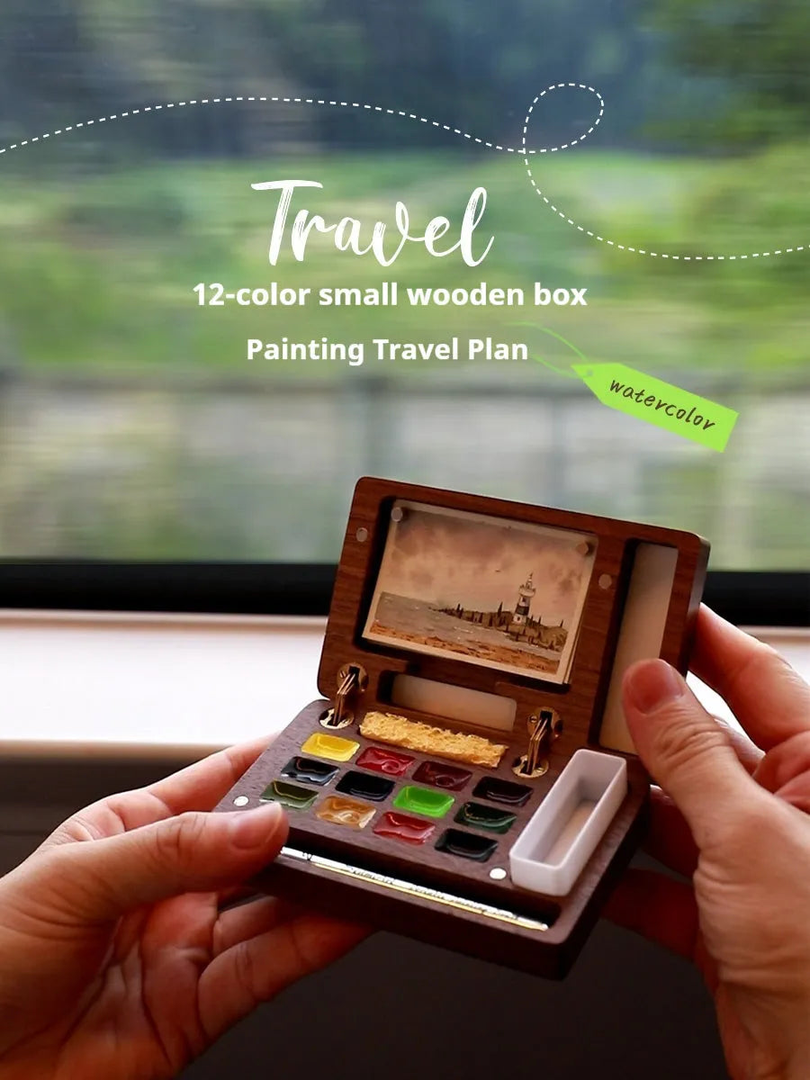 Mini wooden watercolour paint box open showing professional pigment compartments with carrying handle