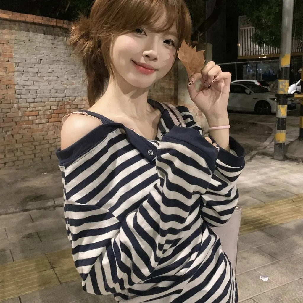 Dark blue Korean-style women's oversized long sleeve t-shirt with stripe and embroidery details on a hanger.