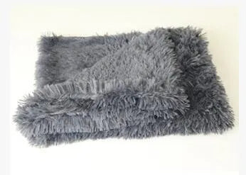Soft long plush dog blanket in dark grey colour on a wooden floor