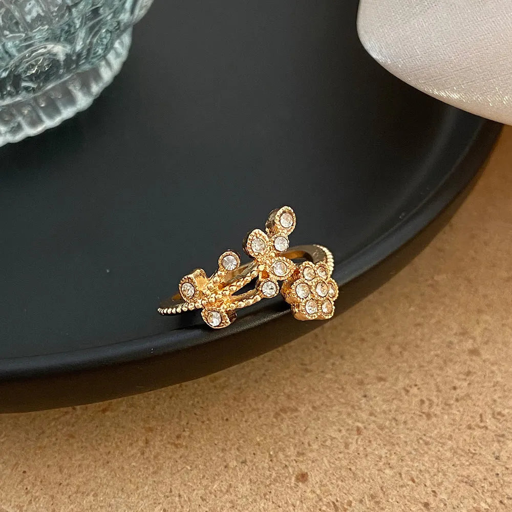 Women's open back copper ring with floral leaf design in a white diamond finish.