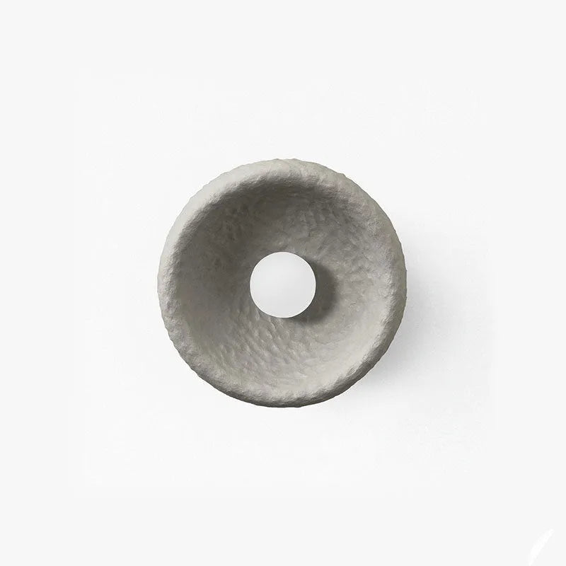Japanese minimalist wall lamp with a round resin shade, shown in a modern room setting.