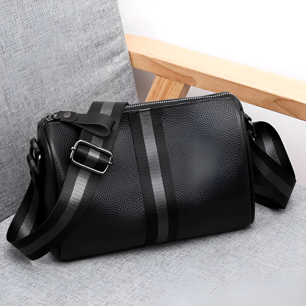Black genuine leather one-shoulder crossbody bag showing its large size and crossbody strap.