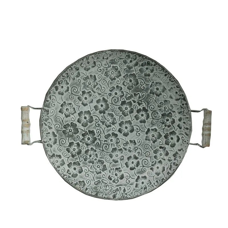 Round wrought iron storage tray in two sizes on a wooden surface