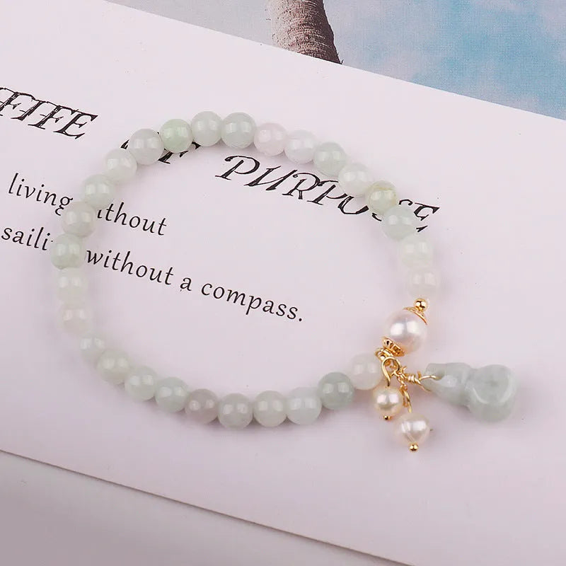 Emerald green jade bracelet with a raised gourd design in a Chinese style.