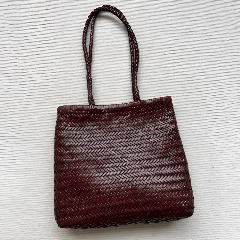 Brown handmade woven leather tote bag with three-dimensional pocket showing vintage texture