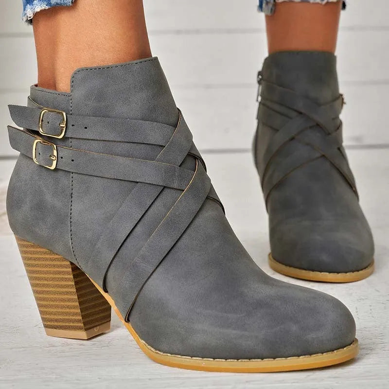 Women's grey ankle boot with a side zipper, buckle detail, and a 7cm rubber heel.